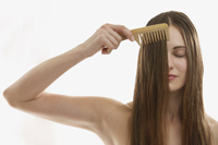 Young woman runs comb through hair - Alex Mares-Manton