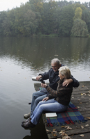 Senior couple enjoying morning coffee on wooden pier - Alex Mares-Manton