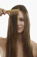 Young woman combing long brown hair - Alex Mares-Manton