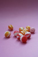 unwrapped hard candies on pink paper - Ellery Chua