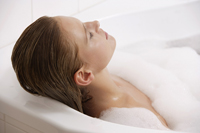 Profile of woman reclining in bath tub - Alex Mares-Manton