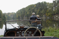 Senior couple looking at lake, in front of antique car - Alex Mares-Manton