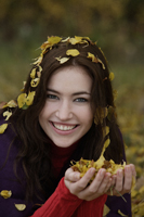 Young woman with fall leaves in hands and hair - Alex Mares-Manton