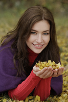 Young woman with handful of golden leaves - Alex Mares-Manton