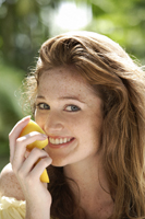 Young woman smelling lemon - Alex Mares-Manton