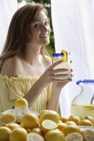 Young woman holding fresh lemonade - Alex Mares-Manton
