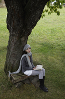 Young woman with book under tree - Alex Mares-Manton