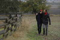 couple walking alongside fence - Alex Mares-Manton
