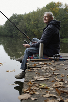 Senior man fishing from pier - Alex Mares-Manton