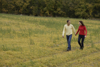 Young couple walking through meadow - Alex Mares-Manton