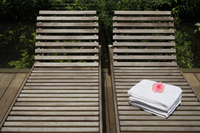 Pair of wooden lounge chairs, stack of towels - Alex Mares-Manton