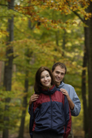 Young couple in hiking clothes standing in forest - Alex Mares-Manton