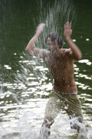 Young man splashing water in lake - Nugene Chiang