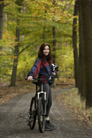 Young woman taking rest from biking through forest - Alex Mares-Manton