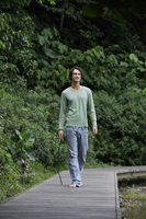 Young man walking on boardwalk - Nugene Chiang