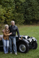 Senior couple leaning against antique car - Alex Mares-Manton