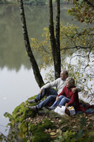 Senior couple picnicking by lake - Alex Mares-Manton