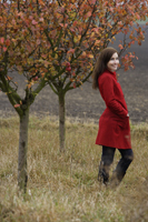 young woman standing in apple orchard - Alex Mares-Manton