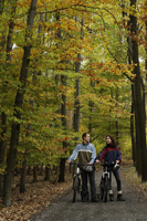 Young couple taking rest from bike ride through forest - Alex Mares-Manton
