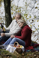 Senior couple having picnic in woods - Alex Mares-Manton