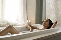 Woman reclining in bathtub - Alex Mares-Manton