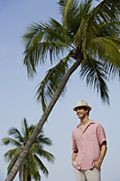 Man standing under palm trees - Alex Mares-Manton