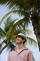 man standing under palm tree - Alex Mares-Manton