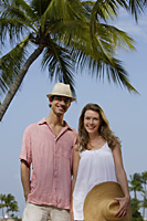 Couple standing under palm tree - Alex Mares-Manton