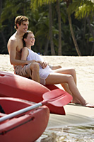 couple sitting on kayak on beach - Alex Mares-Manton