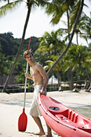 young man pulling kayak up beach - Alex Mares-Manton