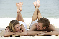 couple relaxing on beach mat - Alex Mares-Manton