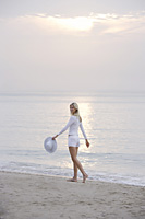 woman walking on beach - Nugene Chiang