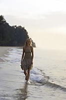 woman walking in morning on beach - Nugene Chiang