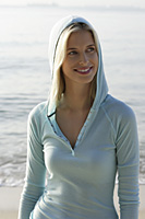portrait of woman wearing blue hoodie on beach - Nugene Chiang