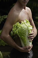 man holding large head of lettuce - Nugene Chiang