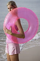 woman at beach with pink tube - Nugene Chiang