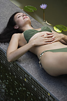 woman reclining poolside, pond side - Alex Mares-Manton