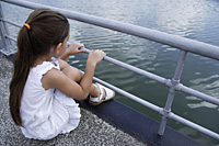 young girl sitting over lake - Nugene Chiang