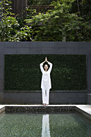woman standing in yoga pose poolside - Alex Mares-Manton