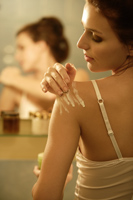 Young woman applying lotion - Alex Mares-Manton