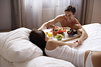 Man serving woman breakfast in bed - Alex Mares-Manton