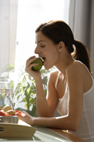 Profile of young woman eating apple - Alex Mares-Manton