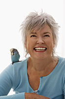 Older woman with blue bird on her shoulder. - Nugene Chiang