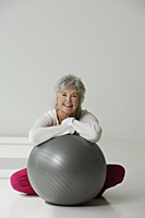 Mature woman relaxing with exercise ball. - Nugene Chiang