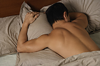 man asleep in bed - Nugene Chiang