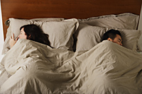 Man and woman sleeping in bed together - Nugene Chiang