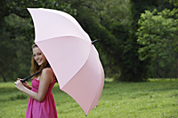 Woman wearing pink dress holding pink umbrella. - Nugene Chiang