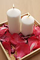 Candles in tray of petals. - Nugene Chiang