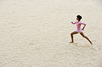 Woman wearing pink running on sand. - Alex Mares-Manton