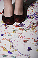 close up of red shoes surrounded by confetti - Nugene Chiang